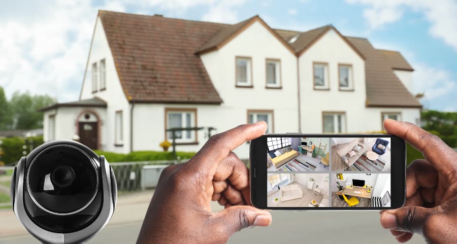 Man holding smartphone and looking at streams from security cameras